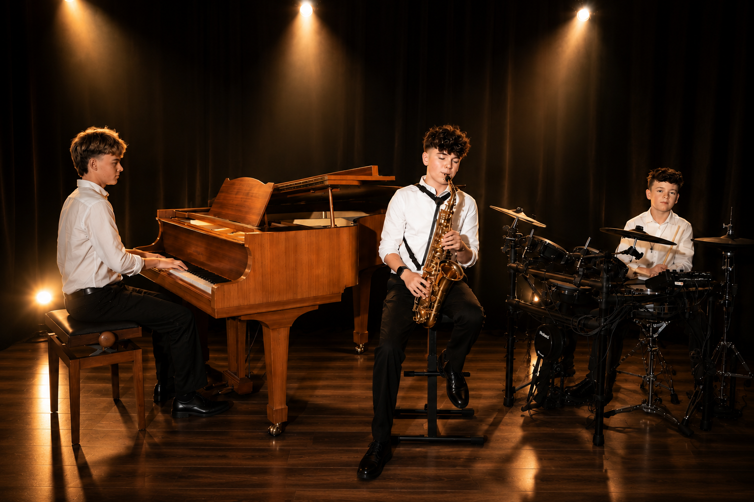 Julian am Klavier, Philipp am Saxophon und Benjamin am Schlagzeug auf einer warm beleuchteten Bühne